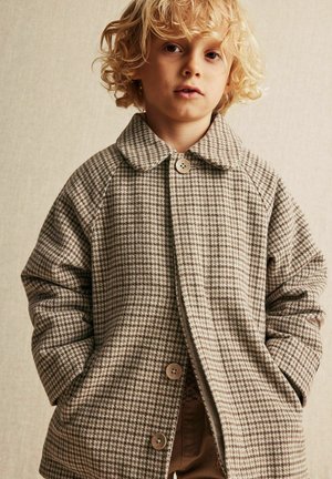 Beige ja ruskean ruutukuosiset takki, jossa on kauluksellinen kaulus ja napitus, valmistettu tekstuurisesta kankaasta.