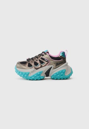 Sapatilha chunky em bronze metálico e malha preta, com sola de borracha teal e detalhes em rosa. Apresenta um design texturizado e uma estrutura de suporte.