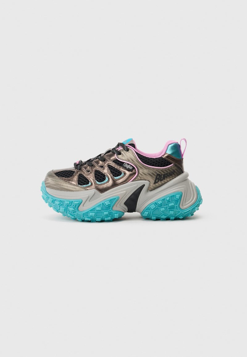 Sapatilha chunky em bronze metálico e malha preta, com sola de borracha teal e detalhes em rosa. Apresenta um design texturizado e uma estrutura de suporte.