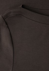 Dunkelbrauner Baumwollstoff mit glatter Textur, ausgestattet mit einem abgerundeten Ausschnitt und geschichteten Designelementen. Keine sichtbaren Muster oder Beschläge.