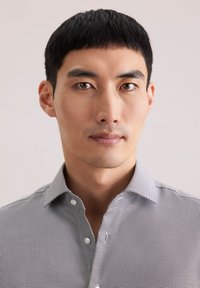 Camicia a righe con bottoni in bianco e nero, con colletto standard, maniche corte e tessuto leggero con motivo strutturato.