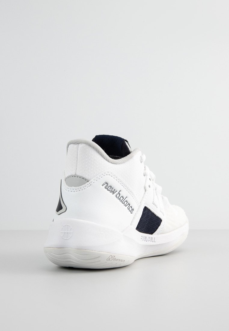 Chaussure de sport blanche avec un dessus texturé, des accents bleu marine et un logo signature. Elle possède une semelle rembourrée et un profil élégant.