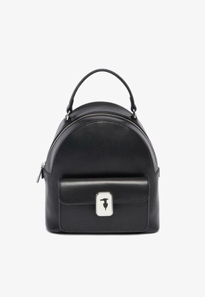 Mochila de cuero negra con la parte superior redondeada, herrajes plateados y bolsillo frontal con solapa. Cuenta con un cierre de cremallera y una superficie texturizada.