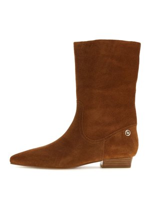 Brązowy zamszowy kozaki do połowy łydki ze spiczastym noskiem, niskim piętrem i małym złotym logo w pobliżu pięty.