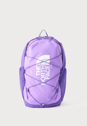 Zaino viola The North Face con cordino elastico frontale e tasche laterali in rete, mostrato in posizione verticale su sfondo chiaro uniforme.