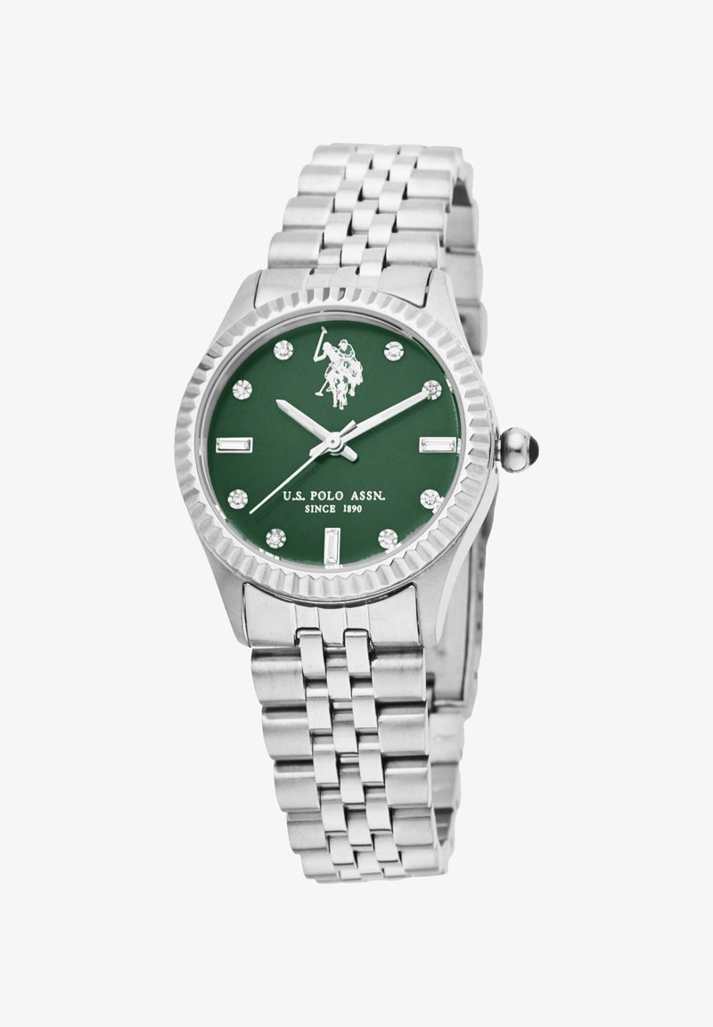 Orologio in acciaio inossidabile argentato con quadrante verde, accentuato da indicatori in cristallo e da un logo argentato. Presenta una lunetta testurizzata e un bracciale a maglie.