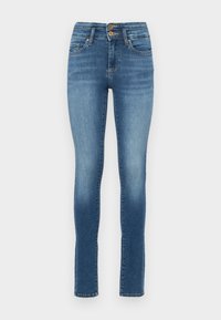 Plave traperice skinny kroja s visokim strukom, koje imaju dva prednja dugmeta, blago izbljeđivanje i standardne džepove. Glatka tekstura, ravne nogavice.
