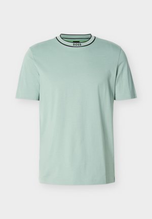 T-shirt vert menthe clair à manches courtes en coton doux. Il présente un col rond avec un bord noir et blanc, ainsi qu'un logo sur le col.