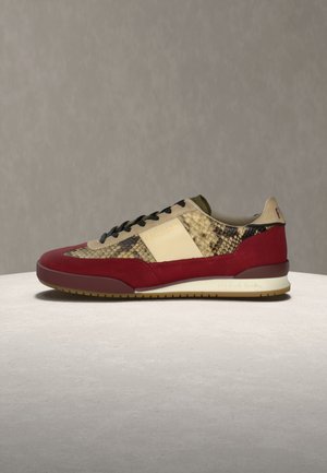 Lav profil sneakers med rødt semsket skinn, beige slangeskinnsmønster, svarte lisser og kremfargede detaljer på nøytral overflate og bakgrunn.