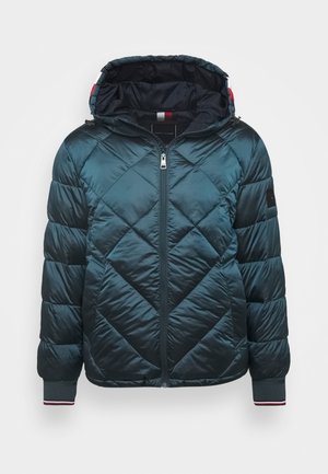 Tmavě zelená prošívaná péřová bunda s kapucí, předním zipem, žebrovanými manžetami s červenými a bílými pruhy a černou nášivkou na levém rukávu.