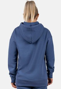 Felpa blu navy con tessuto testurizzato, cappuccio con cordino e polsini e orlo a coste. Nessun motivo o dettaglio in metallo visibile.