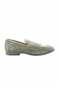Scarpa slip-on in suede verde con punta arrotondata, dettagli cuciti e suola bassa in gomma nera. Texture liscia con design minimalista.