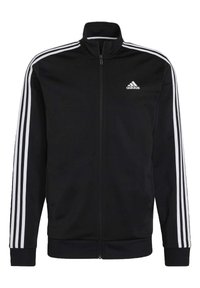 Chaqueta negra con cremallera hecha de una tela suave que presenta tres franjas blancas a lo largo de los hombros y las mangas, con un logo de Adidas en el pecho.