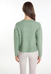 Mintgrüner, oversized Pullover aus weichem Stoff. Mit einem gerippten Saum und Bündchen, einem runden Ausschnitt und überschrittenen Schultern.
