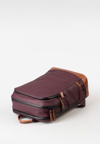 Zaino bordeaux con dettagli in pelle, design snello, doppia cerniera, tessuto testurizzato e maniglia superiore per un facile trasporto.