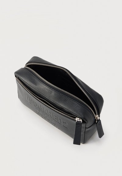 Μαύρο δερμάτινο πορτοφόλι με υφή, διπλό φερμουάρ, δύο ξεχωριστές θήκες και ανάγλυφο όνομα της μάρκας στην μπροστινή τσέπη.