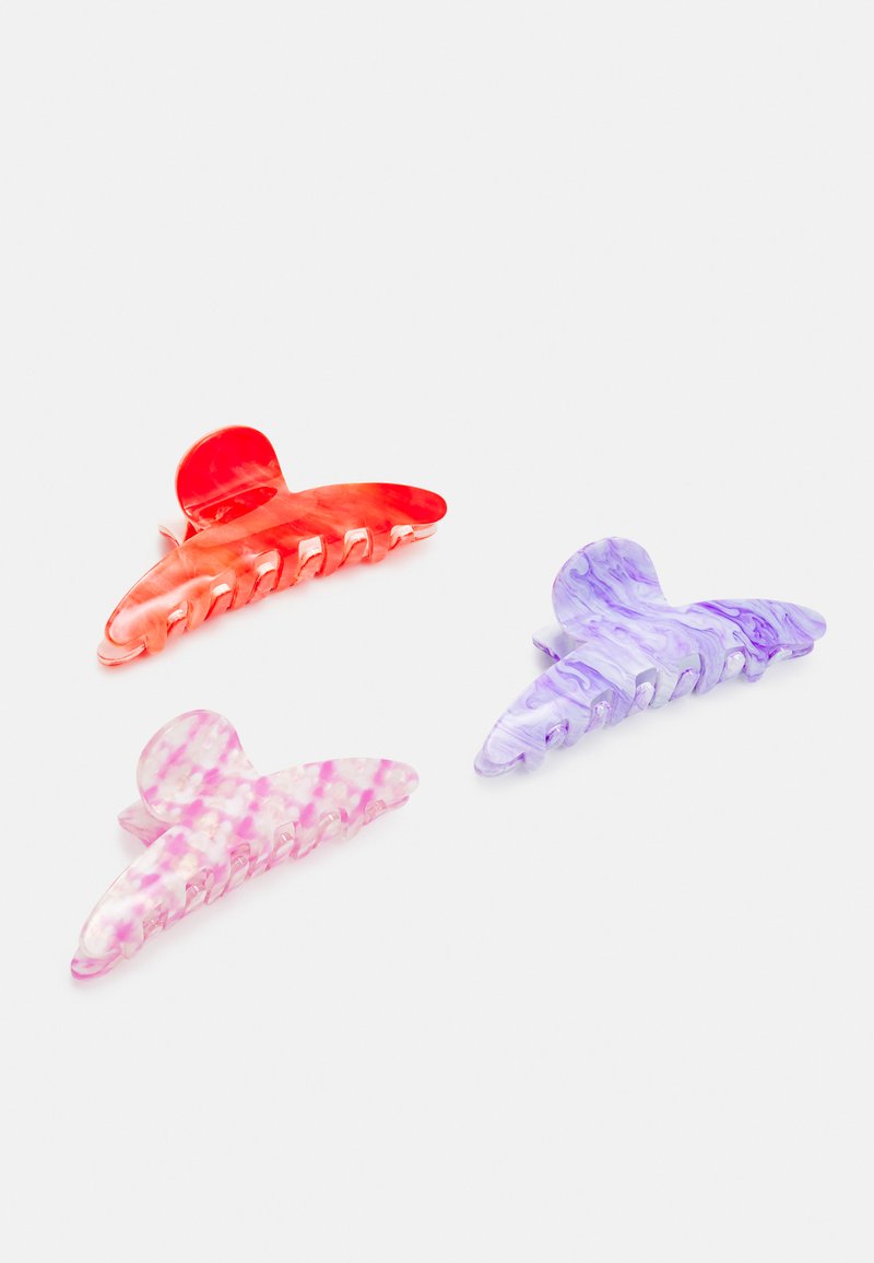 Set of three hair clips made of translucent plastic. Colors include red, pink marbled, and purple with a wavy design and teeth for grip.