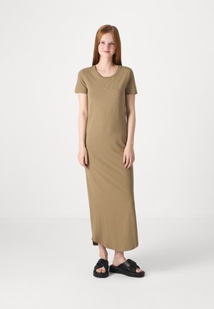 Olivengrønn, kortermet, kroppsnær maxikjole laget av myk stoff, med rund halsutskjæring og rett silhuett. Brukt med svarte slip-on sandaler.