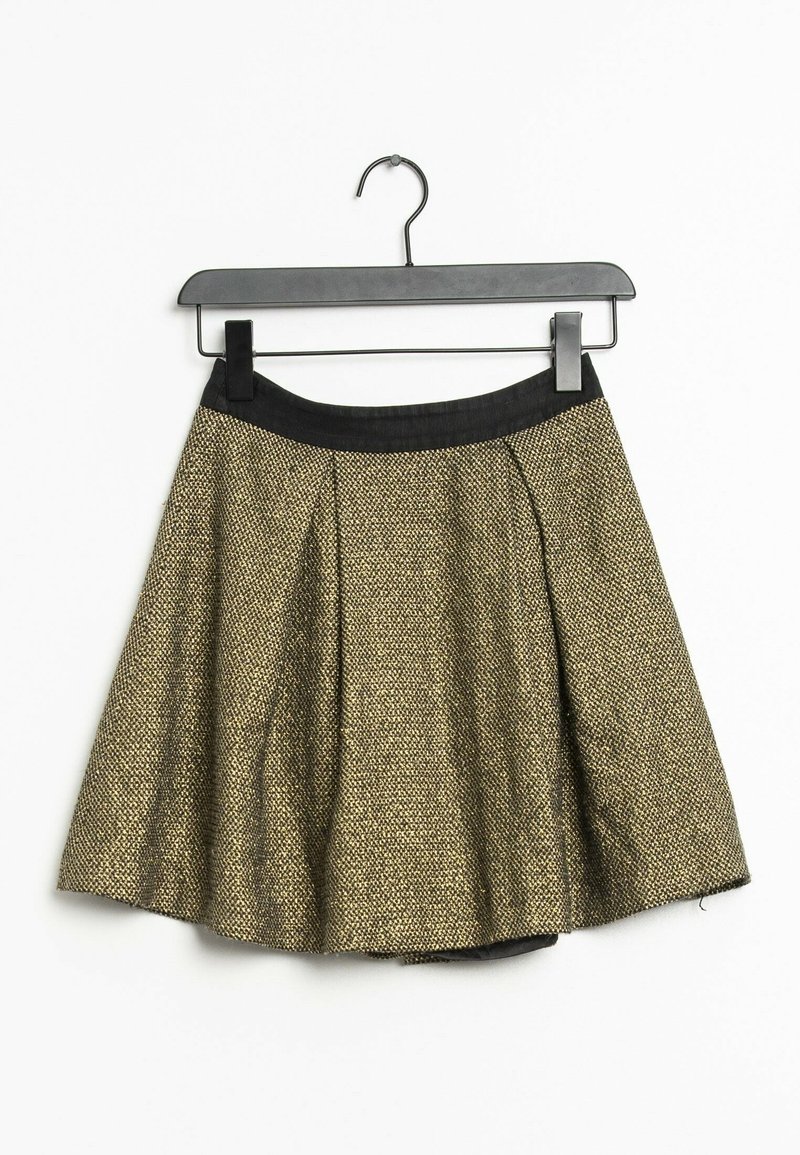 Une jupe plissée en tissu texturé doré et noir, avec une ceinture noire, accrochée à un cintre en plastique noir.