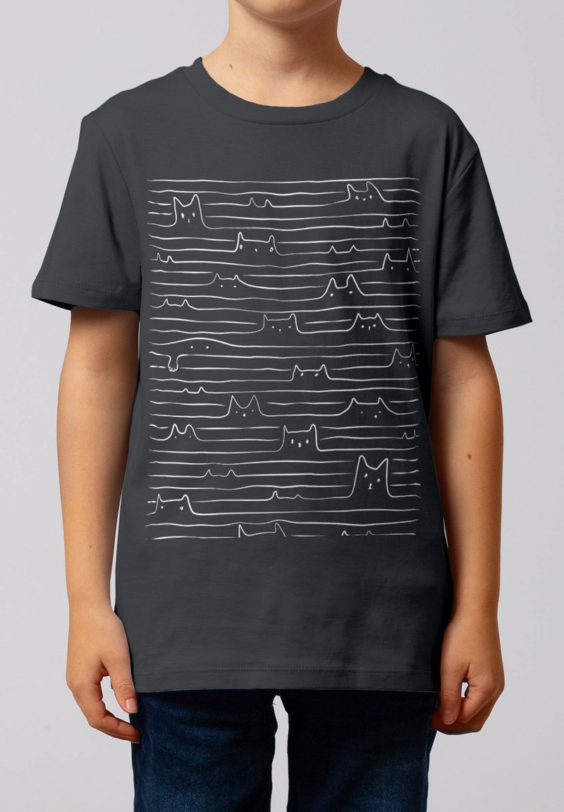 Enfant portant un T-shirt gris foncé orné de dessins en ligne continue blanche représentant différents visages et pattes de chat, disposés en rangées horizontales.