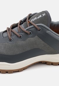 Szare i czarne buty outdoorowe z pomarańczowymi sznurówkami w kropki, teksturowana cholewka, wyściełana podeszwa i gumowa podeszwa z bieżnikiem w kolorze brązowym.