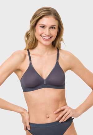 Grauer, nahtloser Wireless-BH mit V-Ausschnitt, verstellbaren Trägern und einem breiteren Bündchen. Weiche Textur und minimalistische Markenkennzeichnung entlang des Bündchens.