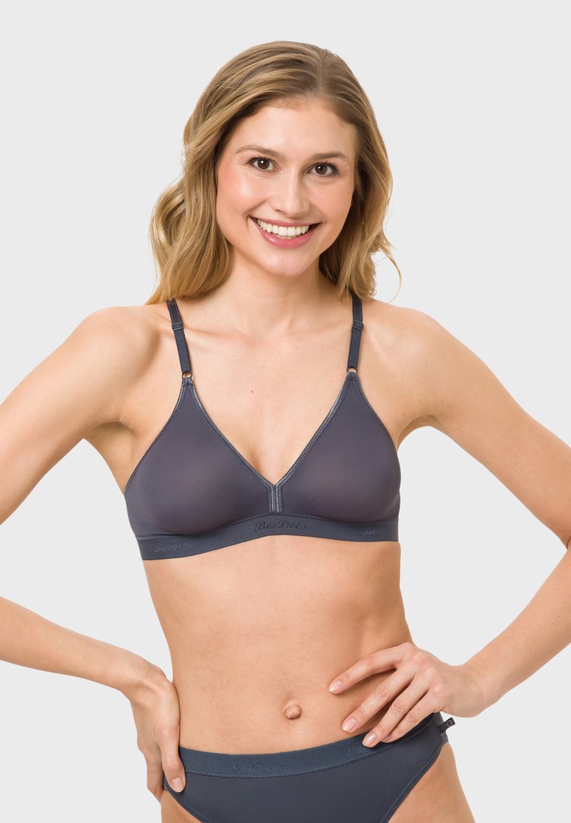 Gray, seamless wireless bra with a V-neck design, adjustable straps, and a wider band. Soft texture and minimalistic branding along the band.