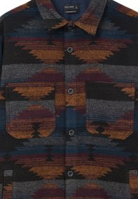 Giacca camicia in lana dalle tonalità scure, caratterizzata da motivi geometrici in arancione, bordeaux e teal, con due tasche frontali e un colletto classico.