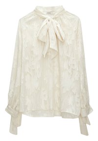 Blouse crème à manches longues avec motif floral texturé, col montant et détail nœud papillon à l’avant, avec une coupe ample et des liens aux poignets.