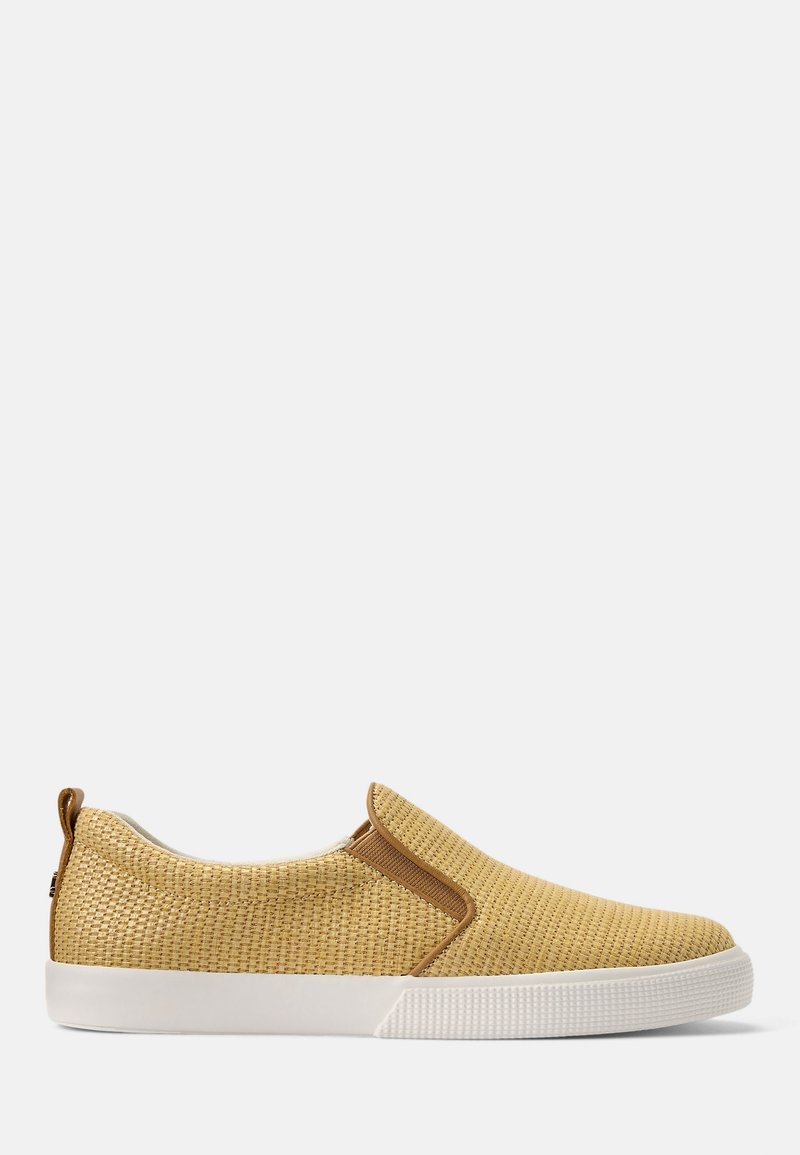 Glidskor i ett vävt gult textil med en vit gummisula och bruna elastiska detaljer. Rundad tå och vadderad kant för komfort.