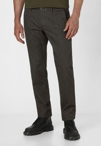 Men's dark grey trousers with a straight fit, made of textured fabric. Features a front button closure and are worn with black lace-up boots.