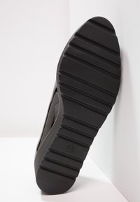 Musta kenkäpohja vaakasuorilla urilla, joka esittelee kumimateriaalin, py�öreä kärki ja sivulla näkyvä kokomerkintä (37).