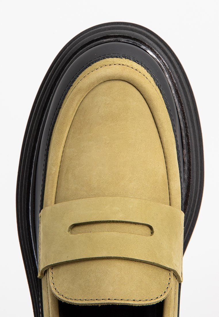 Półbuty w jasnożółtym zamszu z gładką czarną lakierowaną skórzaną lamówką i grubą teksturowaną czarną podeszwą. Posiadają ozdobny pasek z wycięciem.