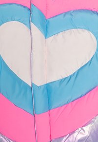 Giacca imbottita con un design a cuore, in colori rosa, azzurro chiaro e crema, con un accento argentato lucido lungo la cerniera e le cuciture.