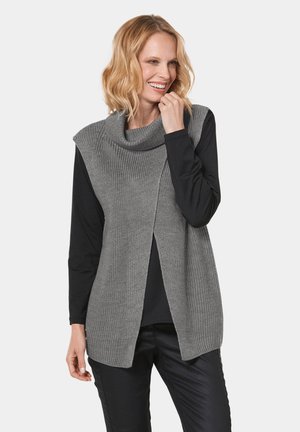 Un pull sans manches en tricot gris avec un col bénitier, présentant un design texturé et une véritable ouverture à l'avant, superposé à un haut à manches longues noir.