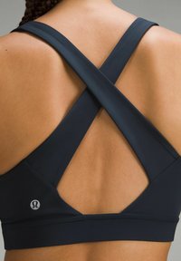 Zwarte sportbh met een crisscross-ontwerp aan de achterkant, gemaakt van soepele, rekbare stof, met een klein logo aan de linkerkant.