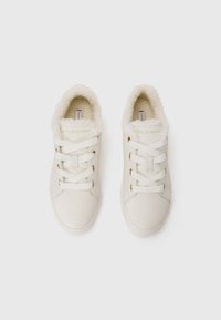 Baskets blanches en cuir avec doublure en fausse fourrure, dotées de garnitures en métal doré et de lacets blancs, affichant un design épuré et minimaliste.