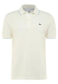 Polo en coton crème à manches courtes, avec un col bleu clair et un petit logo crocodile vert sur la poitrine gauche.