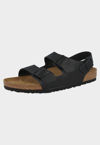 Sandalo nero a due strap con fibbie regolabili, suola in sughero e suola in gomma testurizzata, caratterizzato da un design ampio e aperto per favorire la traspirazione.