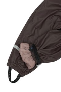 I pantaloni marroni impermeabili presentano un polsino elasticizzato rosa chiaro con una tracolla regolabile, hardware nero e una striscia riflettente per una maggiore visibilità.