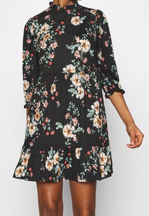 Robe noire à fleurs avec des manches longues et un ourlet à volants. Présente des fleurs roses et jaunes, un tissu texturé et un col haut.