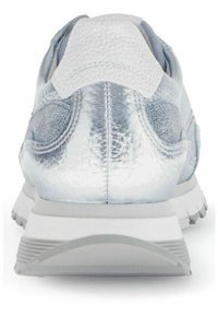 Stříbrná sportovní bota s texturovaným metalickým svrškem, polstrovaným límcem a světlou šedou gumovou podrážkou. Zpevněná pata pro podporu.