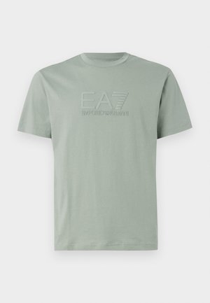 T-shirt en coton vert clair à manches courtes. Présente un logo en relief avec l'inscription "EA7 Emporio Armani" à l'avant. Col rond.