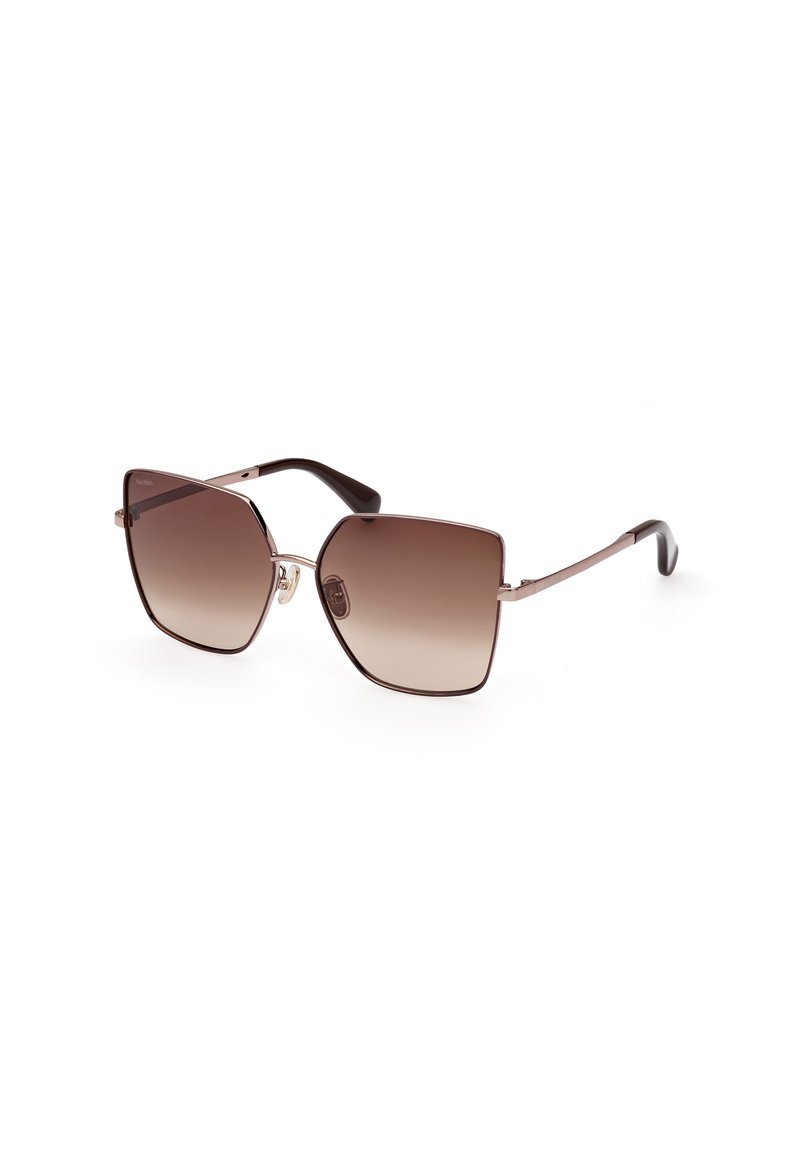 Gafas de sol con gradiente marrón y una montura geométrica de gran tamaño. Accentos metálicos y puntas marrones oscuras en brazos delgados. Acabado suave.