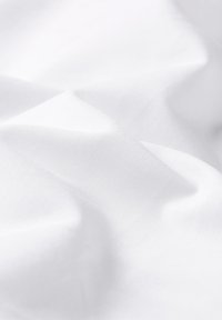 Valkoinen kangas, jossa on sileä rakenne, pehmeitä ryppyjä ja hienoa kiiltoa. Materiaali vaikuttaa kevyeltä ja monipuoliselta eri käyttötarkoituksiin.