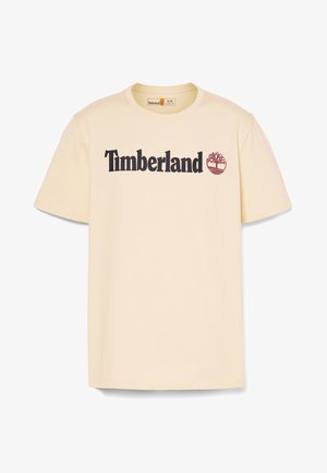 T-shirt in cotone crema con scollatura rotonda e maniche corte. Presenta il testo nero "Timberland" e un logo di un albero color bordeaux sul davanti.