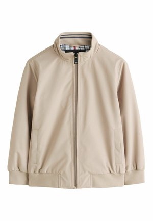 Beige jakke med lynlås, opretstående krave, to sidelommer, ribstrikkede ærmeender og et ternet mønster som foring inde i kraven.