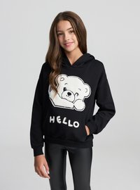 Felpa con cappuccio nera con grafica di un orsacchiotto bianco e soffice e la parola "HELLO" in lettere in grassetto. Include una tasca frontale e un cappuccio con coulisse.