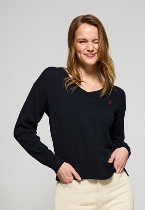Marineblauwe V-hals trui van een zachte, gebreide stof. Heeft lange mouwen en een klein rood logo op de linkerborst.