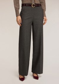 Pantaloni grigi a gamba larga realizzati in tessuto testurizzato, abbinati a una cintura bordeaux con una fibbia circolare dorata.
